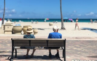 Elder couple sitting on a bench at the beach